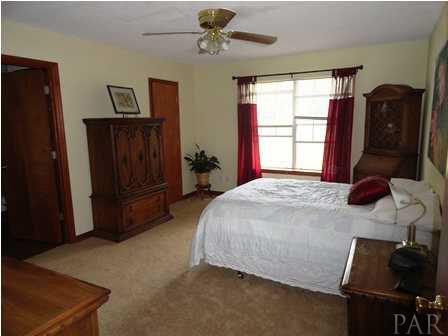 1950 Smyers Road Cantonment, FL 32533 - Photo 17 of 25 a bed sitting in a bedroom next to a window