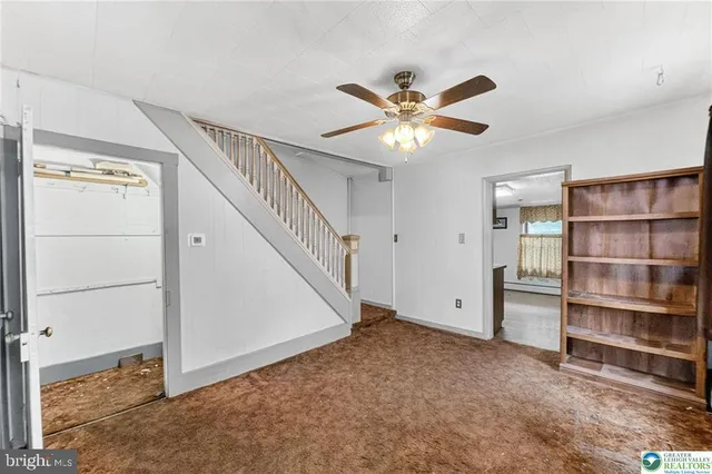 a view of an empty room with a cabinet and a window