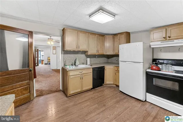 a kitchen with a refrigerator sink and cabinets