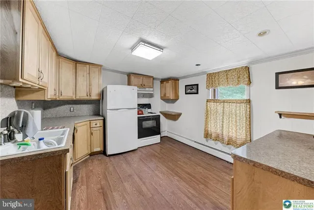 a kitchen with granite countertop white cabinets and white appliances