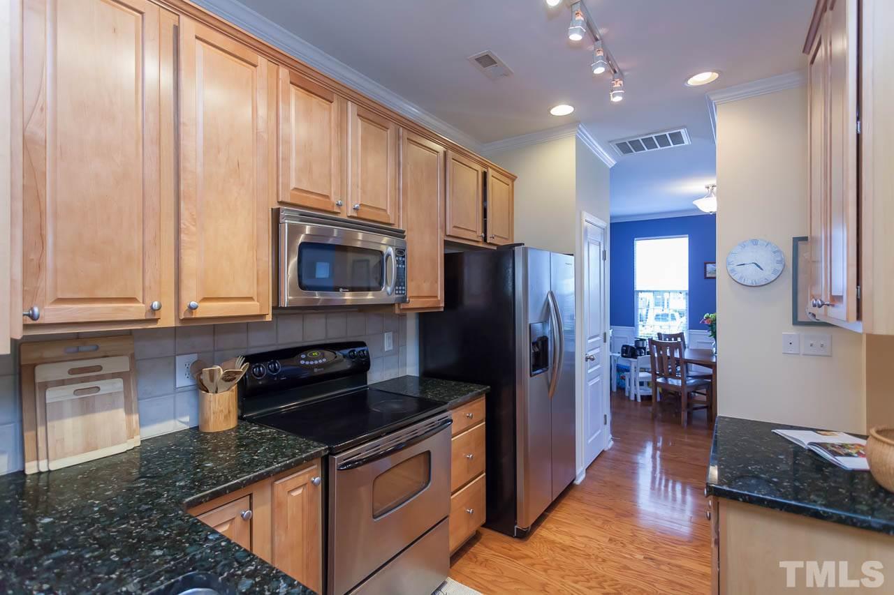 7815 Spungold Street Raleigh, NC 27617 - Photo 11 of 25 a kitchen with granite countertop stainless steel appliances and wooden cabinets