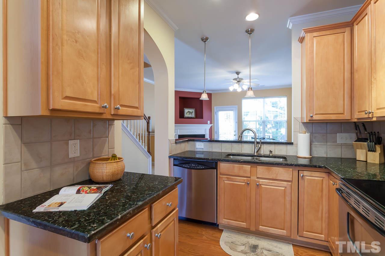 7815 Spungold Street Raleigh, NC 27617 - Photo 13 of 25 a kitchen with granite countertop a sink stove and cabinets
