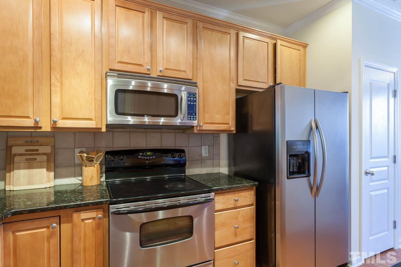 7815 Spungold Street Raleigh, NC 27617 - Photo 14 of 25 a kitchen with granite countertop a refrigerator stove and microwave