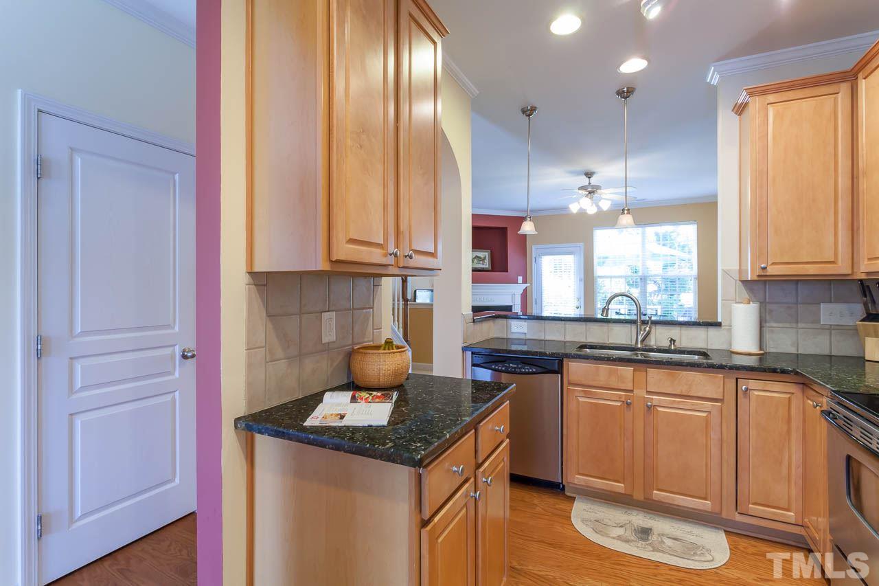 7815 Spungold Street Raleigh, NC 27617 - Photo 15 of 25 a kitchen with a sink a stove cabinets and wooden floor