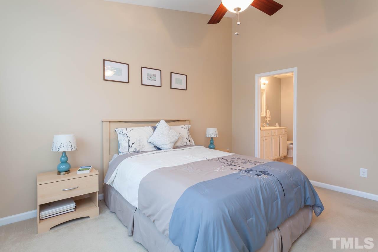 7815 Spungold Street Raleigh, NC 27617 - Photo 21 of 25 a bedroom with a bed and a chandelier fan