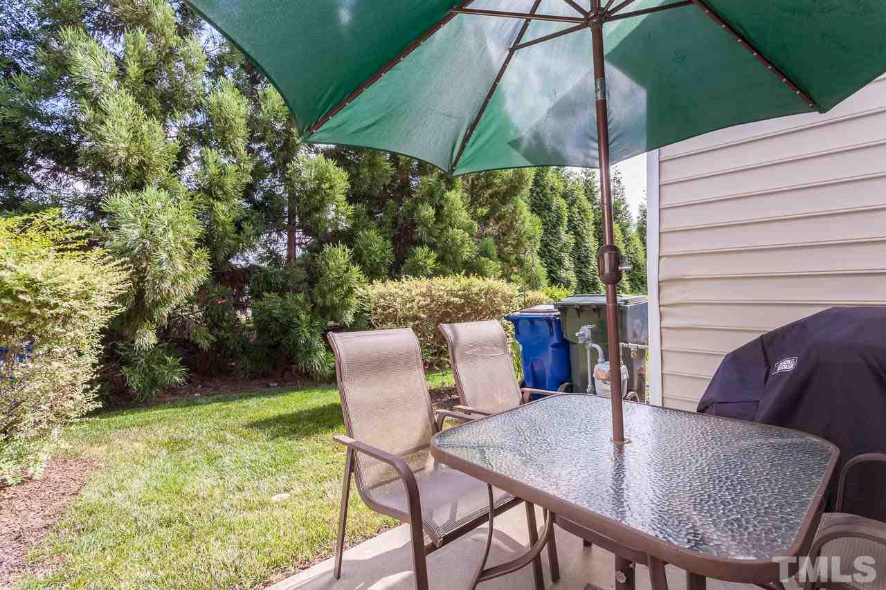 7815 Spungold Street Raleigh, NC 27617 - Photo 23 of 25 a view of a patio with a table chairs and a backyard