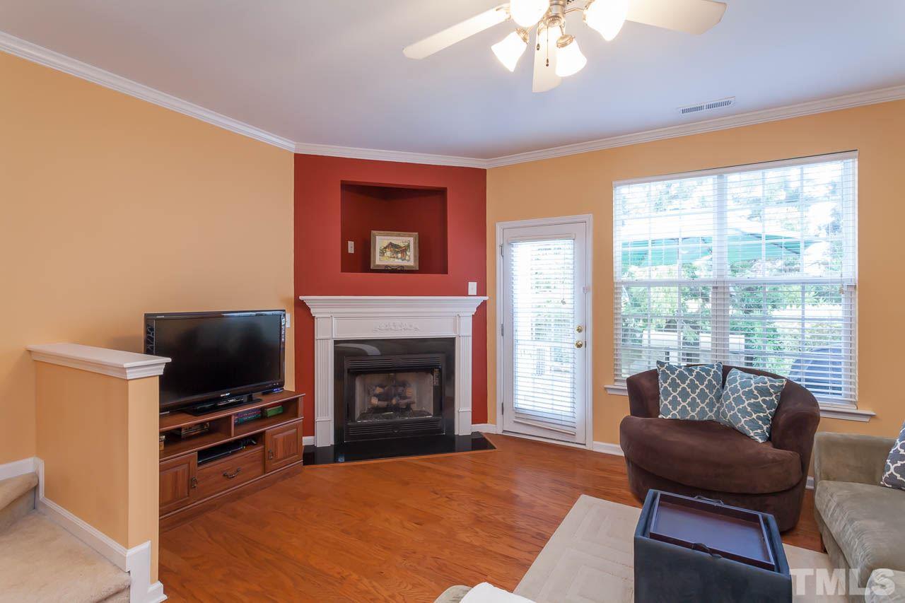 7815 Spungold Street Raleigh, NC 27617 - Photo 9 of 25 a living room with furniture a flat screen tv and a fireplace