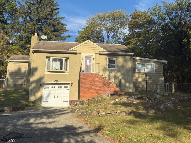 a view of a white house with large windows and a small yard
