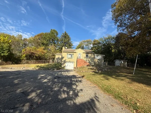 a view of a yard with plants and trees