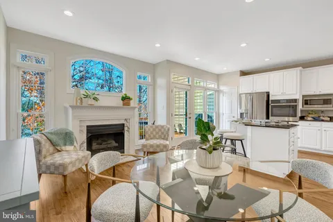 a kitchen with granite countertop a stove a sink a dining table and chairs with wooden floor