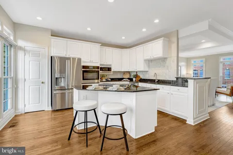 a kitchen with granite countertop a stove and wooden floor