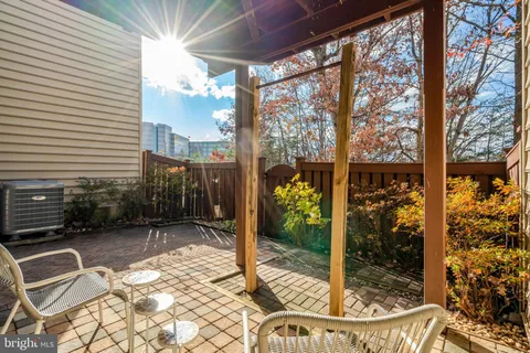 a view of a backyard with chairs and potted plants