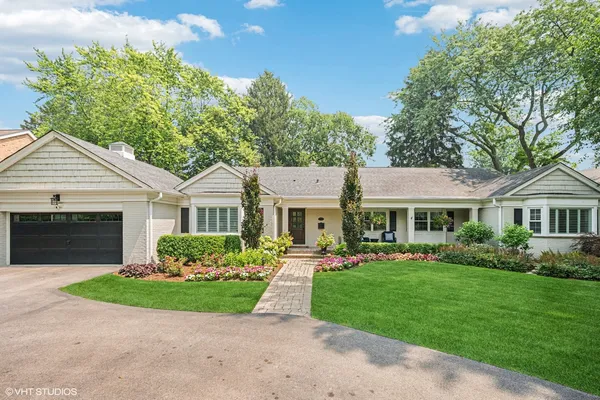 a front view of a house with a garden and plants