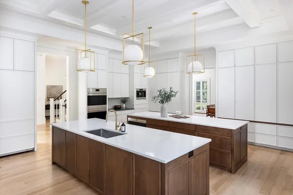 a kitchen with stainless steel appliances a sink a counter space and wooden floor