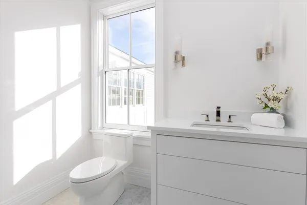 a bathroom with a toilet sink and mirror