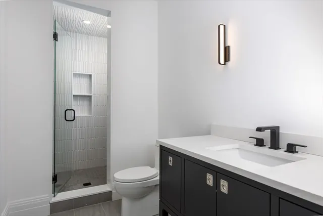 a bathroom with a sink a toilet and shower