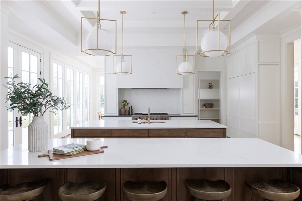 222 Warren Street Brookline, MA 02445 - Photo 4 of 33 a kitchen with kitchen island stainless steel appliances a table chairs in it and wooden floor