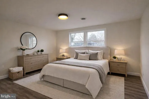 a bedroom with a bed a window and dresser