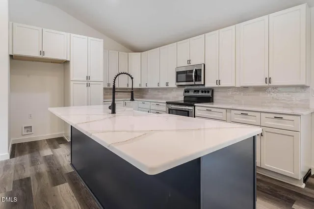 a kitchen with stainless steel appliances a sink a stove a microwave and cabinets