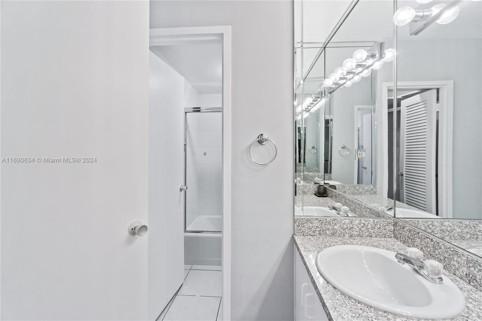 100 Lincoln Road, Unit 1016 Miami Beach, FL 33139 - Photo 12 of 25 a bathroom with a granite countertop sink a mirror and shower
