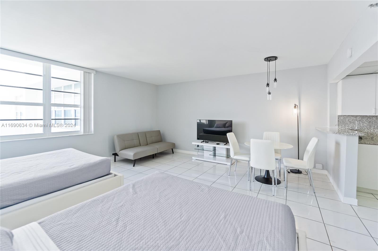 100 Lincoln Road, Unit 1016 Miami Beach, FL 33139 - Photo 5 of 25 a bedroom with a bed a couch and large window