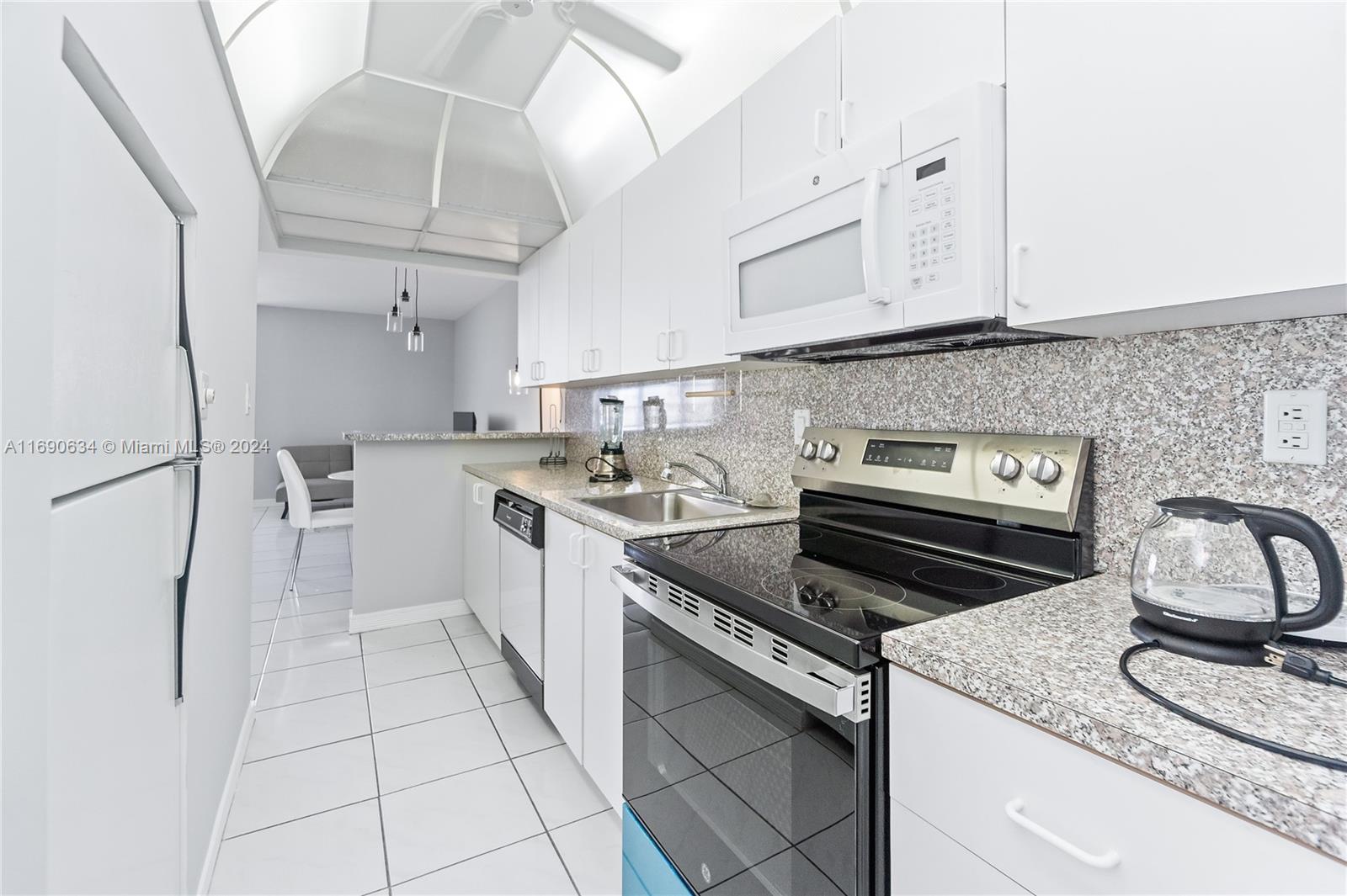 100 Lincoln Road, Unit 1016 Miami Beach, FL 33139 - Photo 9 of 25 a kitchen with stainless steel appliances granite countertop a sink stove and cabinets
