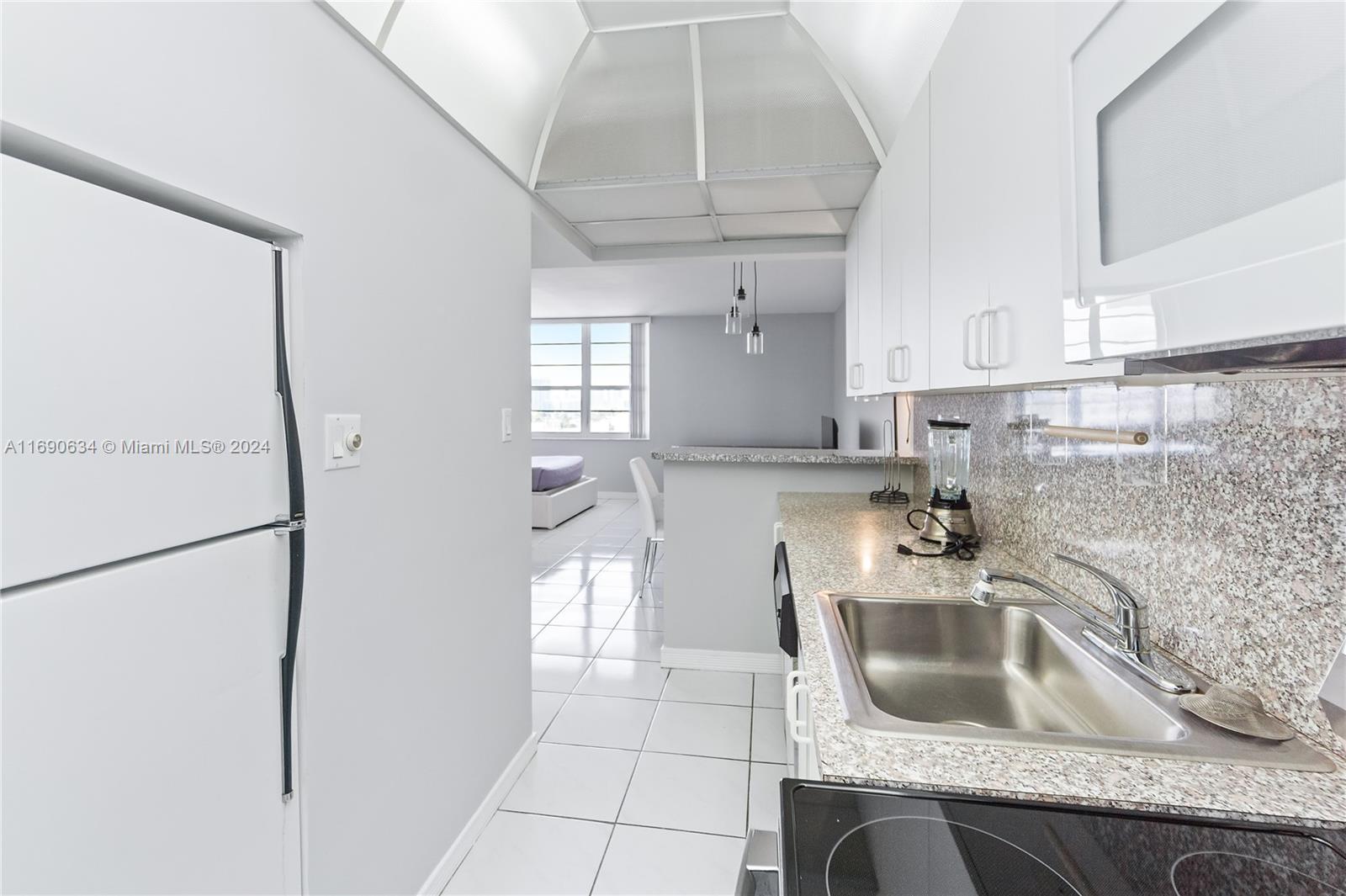 100 Lincoln Road, Unit 1016 Miami Beach, FL 33139 - Photo 10 of 25 a kitchen with stainless steel appliances granite countertop a sink a refrigerator and a granite counter tops
