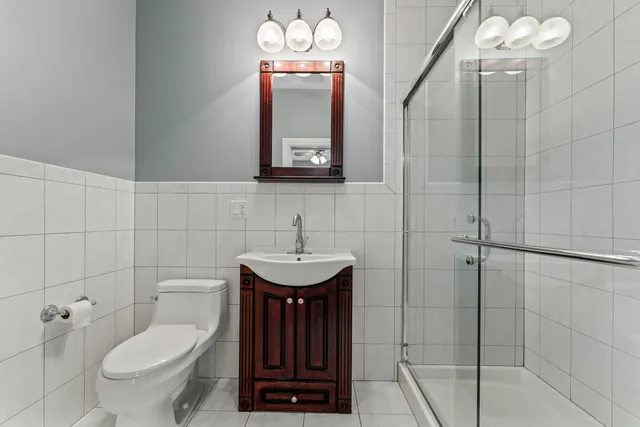 a bathroom with a toilet a sink and mirror