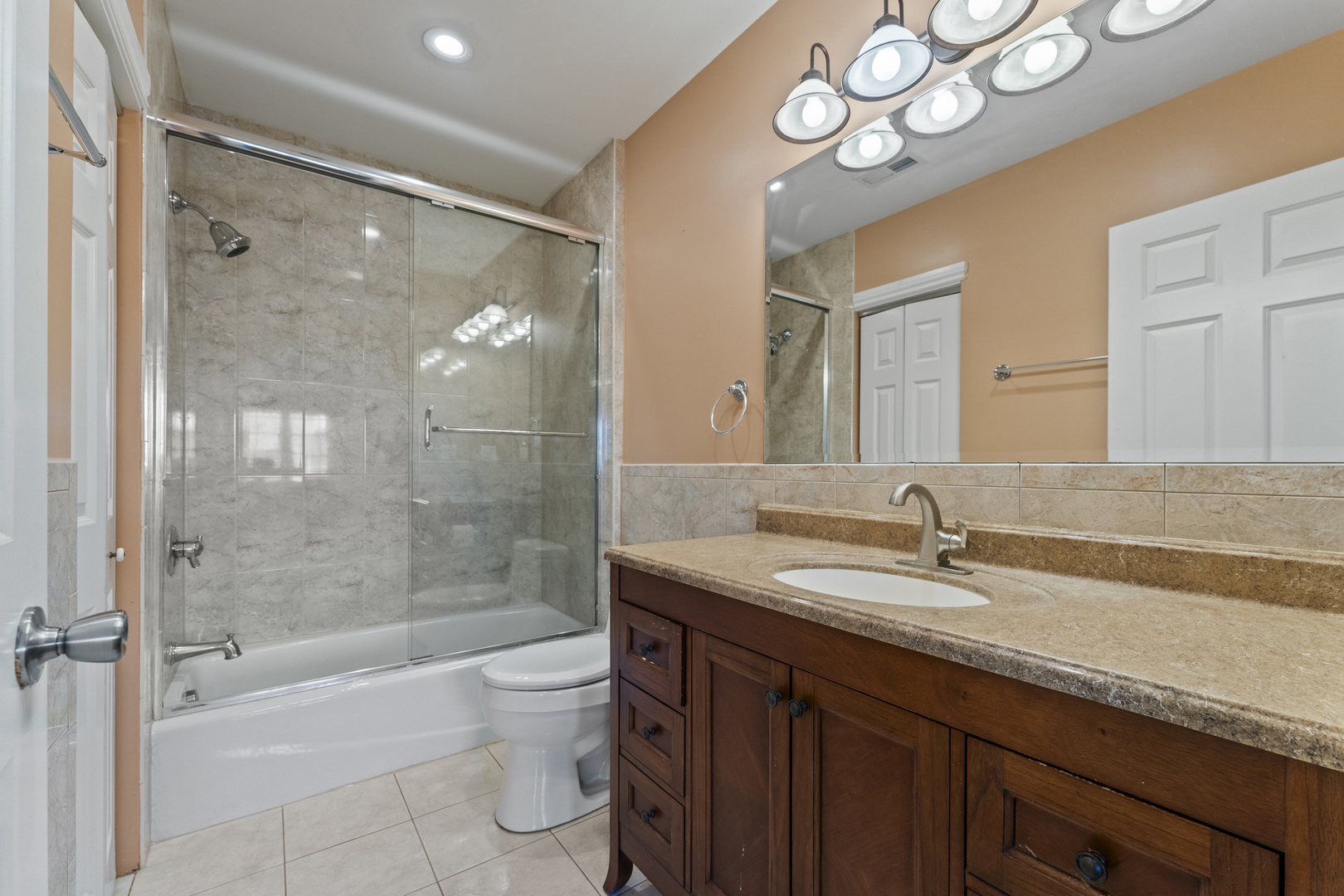5533 Lincoln Avenue Morton Grove, IL 60053 - Photo 23 of 40 a bathroom with a granite countertop sink a toilet a mirror and shower