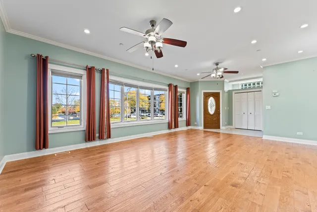 a view of an empty room with window and wooden floor