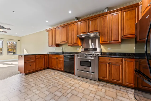 a kitchen with granite countertop a stove top oven sink and cabinets