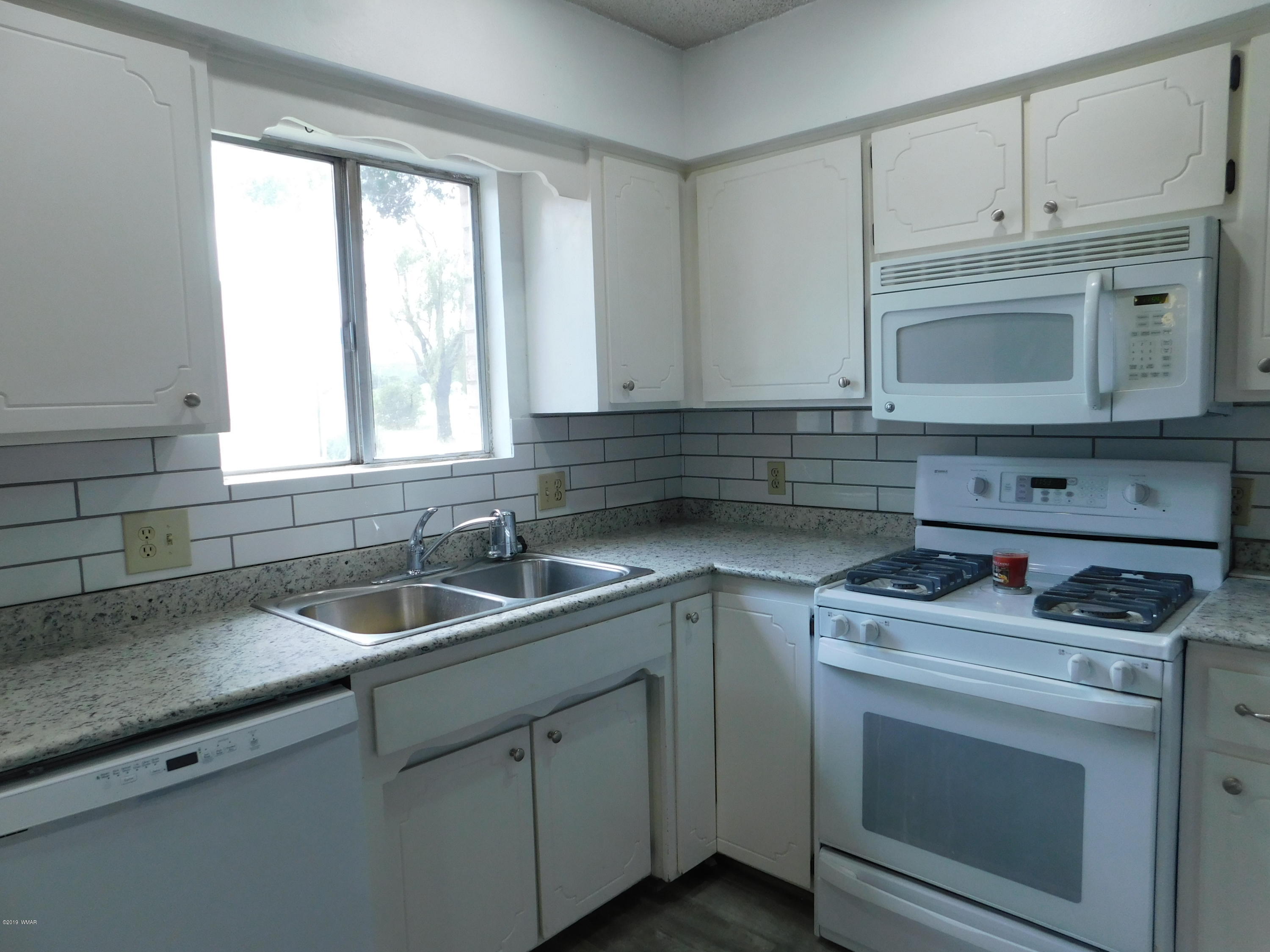 353 Brant Street Eagar, AZ 85925 - Photo 9 of 23 a kitchen with granite countertop a sink stove and microwave