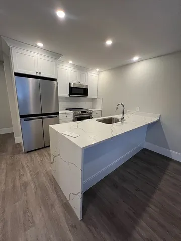 a kitchen with a sink a refrigerator and a stove top oven