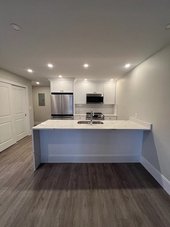 17 Carson Street, Unit 6C Boston, MA 02125 - Photo 5 of 11 a large kitchen with stainless steel appliances wooden cabinets and a wooden floor