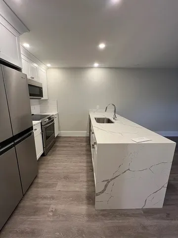 a kitchen with stainless steel appliances a refrigerator sink and microwave