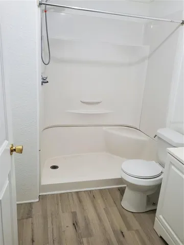 a bathroom with a toilet and a shower