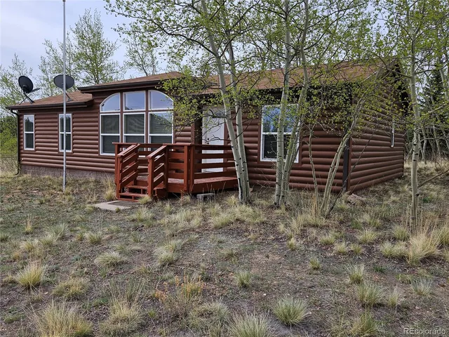 a view of a house with backyard and wooden fence