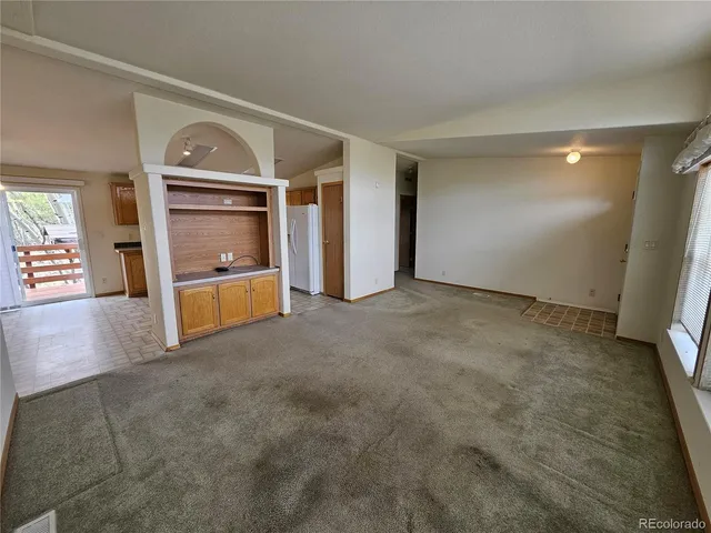 a view of an empty room and window with wooden floor