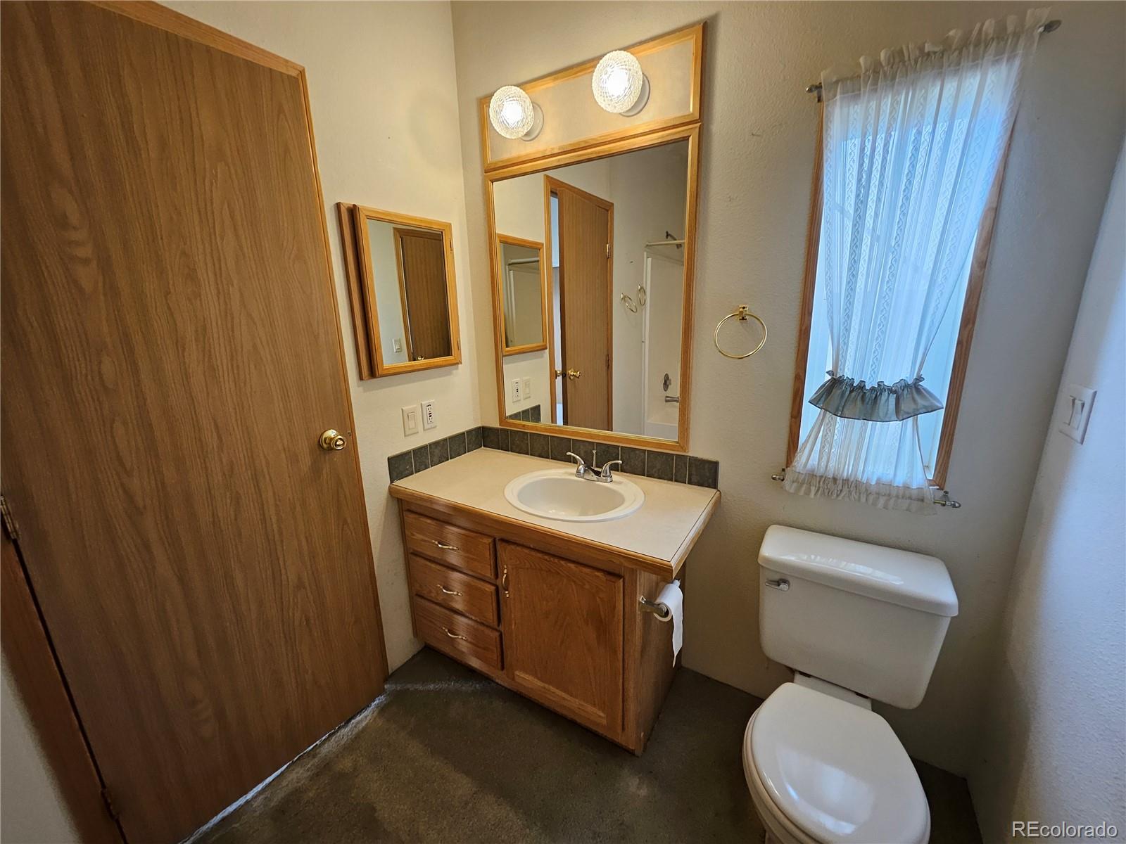 631 Arrowhead Drive Como, CO 80432 - Photo 15 of 45 a bathroom with a granite countertop toilet sink and mirror