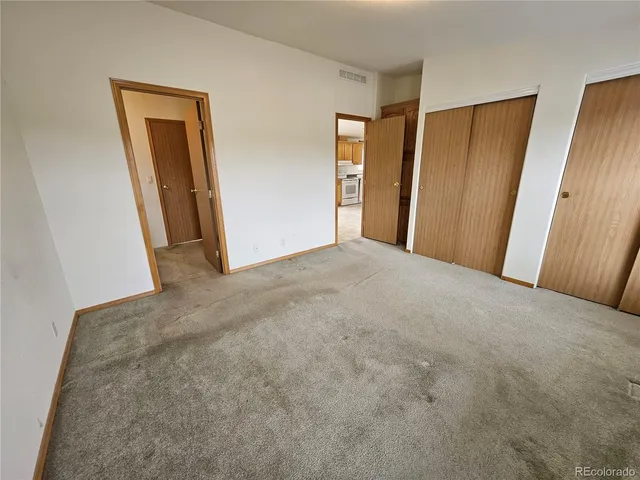 a view of hallway with closet and wooden floor