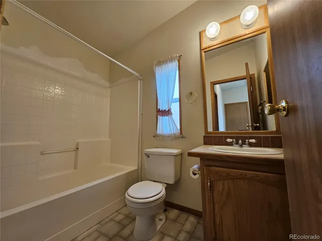 a bathroom with a sink a toilet and shower a mirror