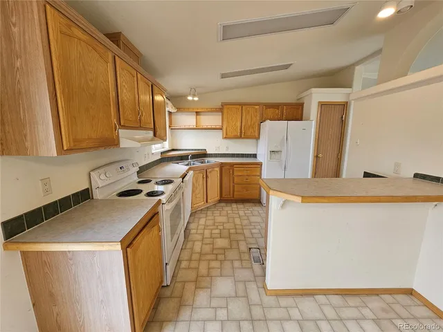 a kitchen with a sink a stove top oven a cabinetry and a potted plant