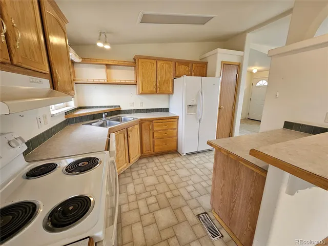 a kitchen with a refrigerator and a stove top oven