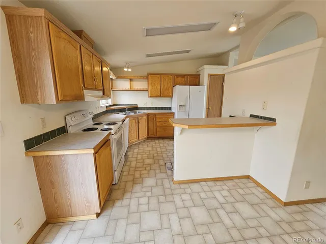 a kitchen with a sink a stove top oven a counter space and cabinets