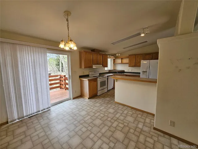 a kitchen with stainless steel appliances granite countertop a refrigerator a sink dishwasher a stove and white cabinets with wooden floor