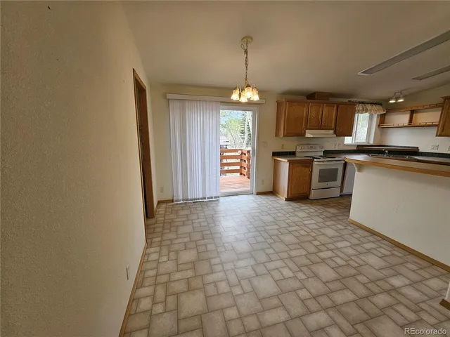 a open kitchen with stainless steel appliances granite countertop a stove top oven a sink dishwasher and a refrigerator with wooden floor