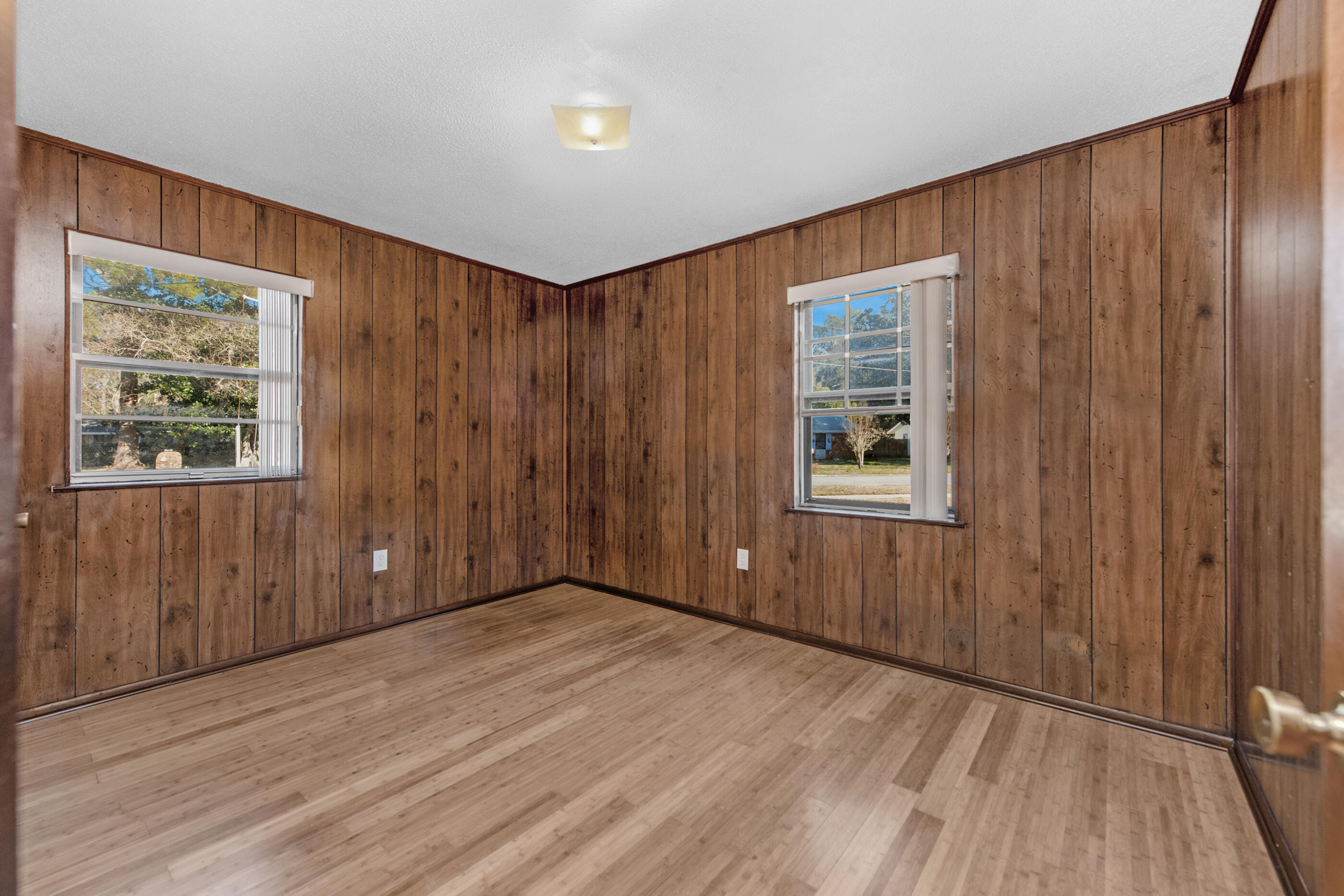 235 Deluna Road Southwest Fort Walton Beach, FL 32548 - Photo 19 of 29 a view of an empty room with wooden floor and a window
