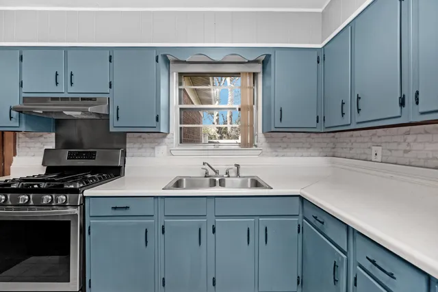 a kitchen with stainless steel appliances granite countertop a sink stove and cabinets