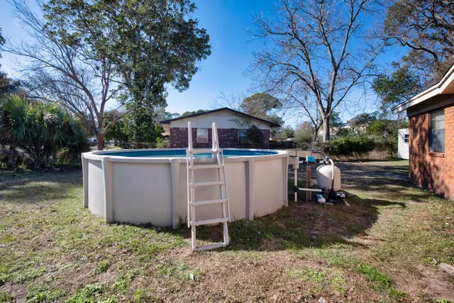 a view of a yard with wooden fence