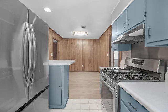 a kitchen with stainless steel appliances granite countertop a refrigerator and a stove